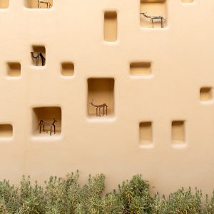 beige color niche wall with animal statuette and plants
